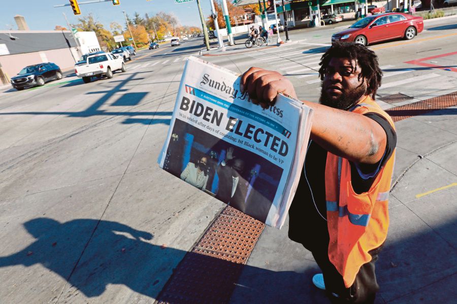 A news vendor in Detroit, Michigan, announcing Joe Biden’s triumph in the US presidential election on Sunday. -AFP pic