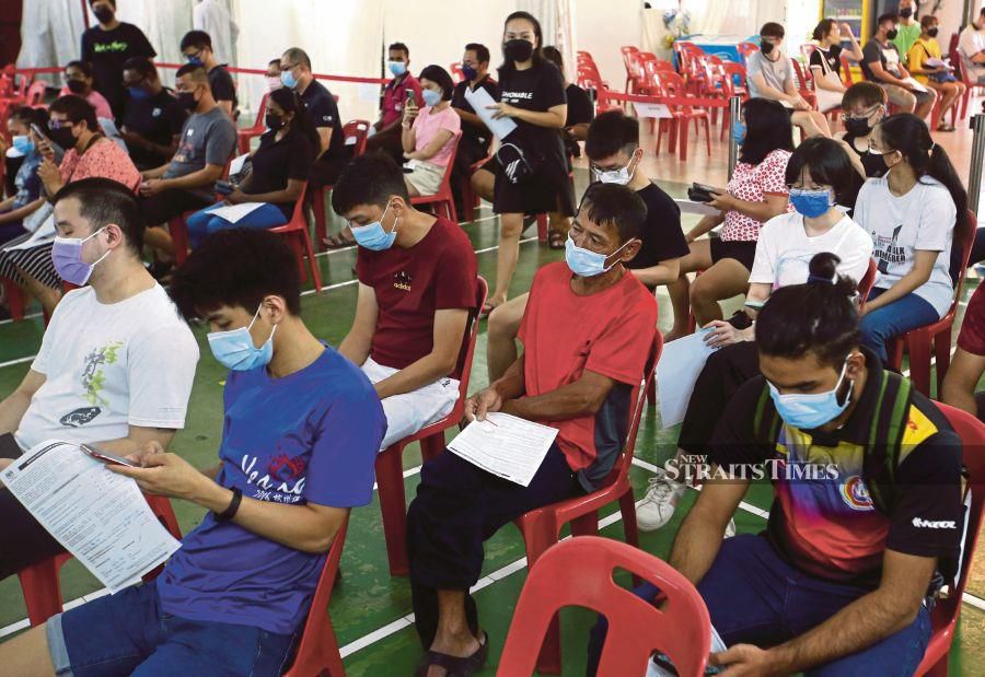  People waiting to be vaccinated against Covid-19 at Dewan Ang Si Chong in Butterworth, Penang, yesterday.  PIC BY DANIAL SAAD 