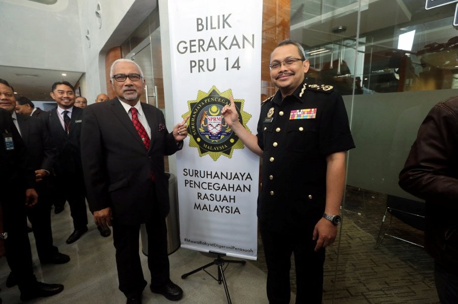 MACC Chief Commissioner Tan Sri Dzulkifli Ahmad (right) with Election Commission chairman Tan Sri Mohd Hashim Abdullah at EC’s GE14 operations room in Putrajaya yesterday. (PIC BY MOHD FADLI HAMZAH)