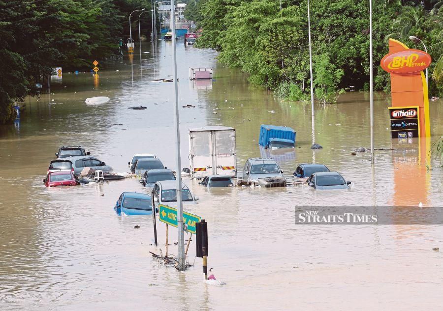 This December 19, 2021 file pic, shows cars inundated with floodwaters at Jalan Sri Muda in Shah Alam. - NSTP/EIZAIRI SHAMSUDIN