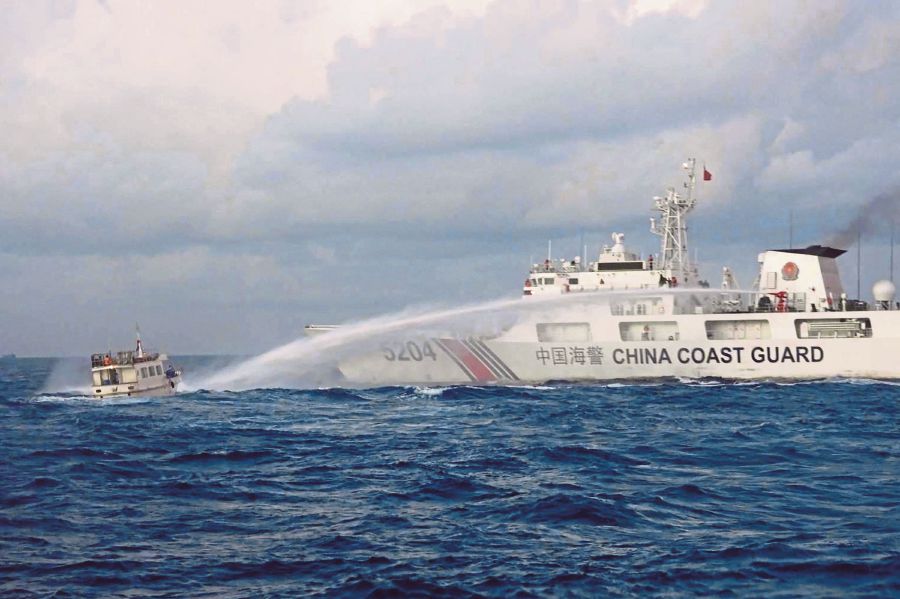 A China Coast Guard vessel (right) using water cannon against the M/L Kalayaan chartered supply boat (left) during a mission to deliver provisions at Second Thomas Shoal in disputed waters of the South China Sea. (Photo by Handout/Philippine Coast Guard (PCG) / AFP) 