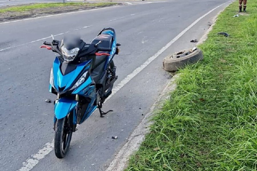 Two men died when the motorcycle they were riding skidded off the road before plunging into a drain this morning. - PIC COURTESY OF POLICE