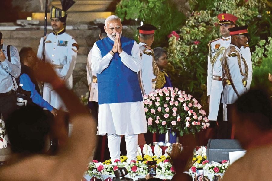  Narendra Modi gesturing to the crowd at the oath-taking ceremony at the Rashtrapati Bhavan presidential palace in New Delhi on Sunday. AFP PIC 