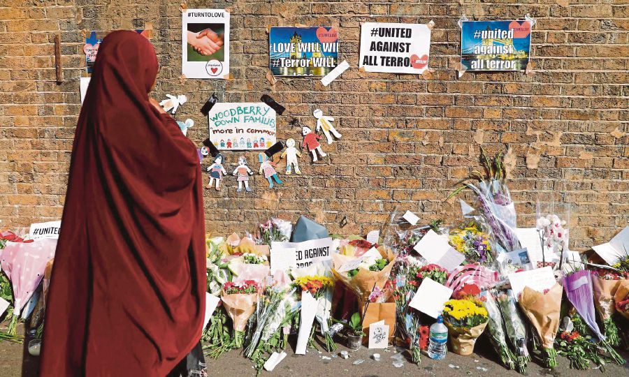 (File pix) A woman placing flowers near the area of the Finsbury Park attack in London last year. AFP Photo