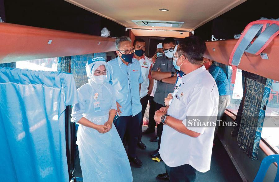 Deputy Rural Development Minister I Datuk Seri Abdul Rahman Mohamad (front, right) inspecting the bus which was turned into a vaccination centre at Paloh 2 near Gua Musang yesterday. 