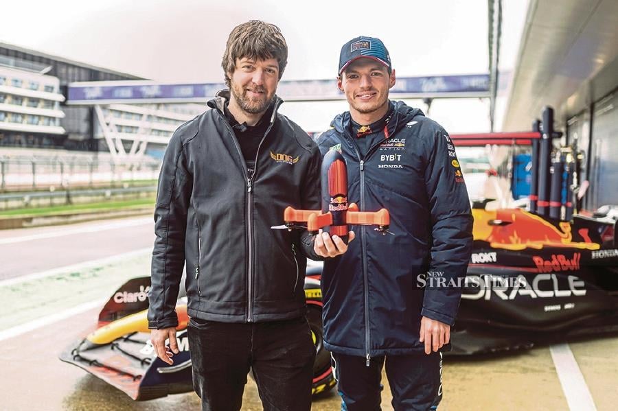Drone pilot Ralph Hogenbirk (left) poses with Red Bull driver Max Verstappen.