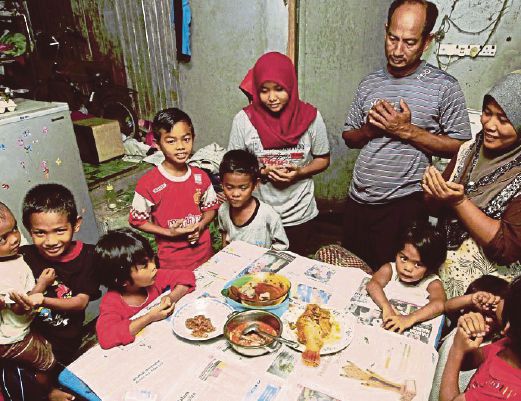 Abdul Ghani Che Omar, his wife Azimah Musa (right) and their children reciting a prayer before breaking their fast at their home in Pasir Mas, Kelantan, yesterday. Pic by Syamsi Suhaimi