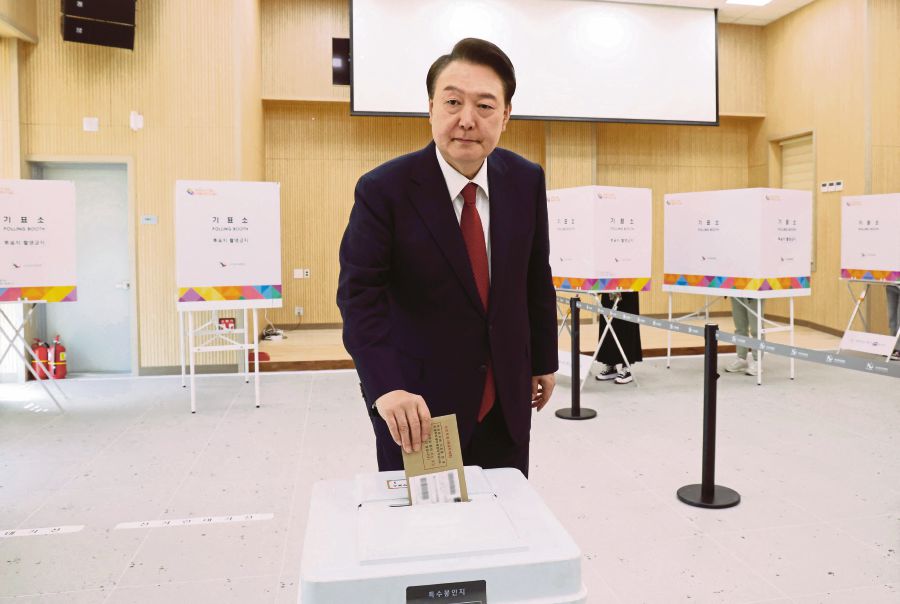  South Korea’s President Yoon Suk Yeol casting his ballot during early voting at a polling station in Busan on April 5, ahead of Wednesday’s parliamentary elections. AFP PIC 