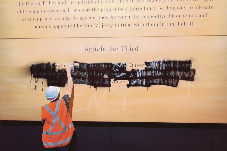 A protester from the Te Waka Hourua group defacing a historic exhibit at New Zealand’s National Museum, Te Papa, in Wellington, on Monday. AFP PIC/TE WAKA HOURUA