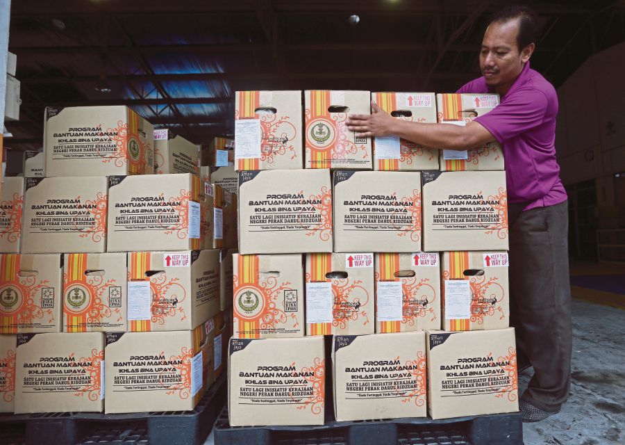 A worker stacking boxes for a food aid programme by Yayasan Bina Upaya Darul Ridzuan in Ipoh. PIC BY ABDULLAH YUSOF