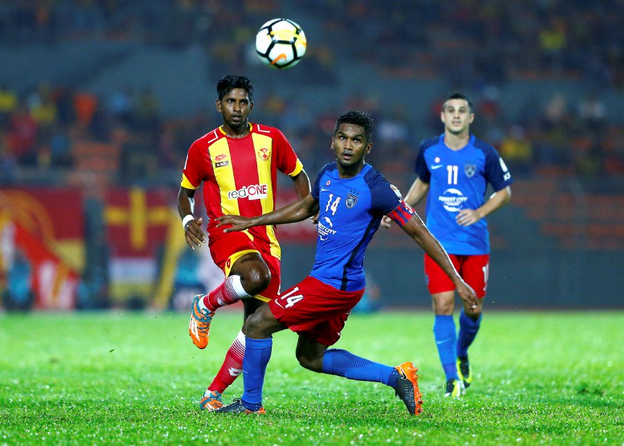 Selangor’s Namathevan Arunasalam (left) is challenged for the ball by Johor Darul Ta’zim’s Harris Harun. Pic by SUPIAN AHMAD
