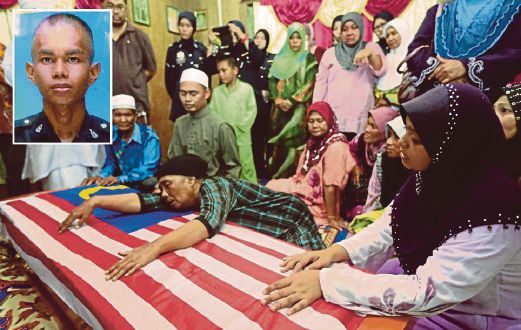 SEMPORNA 13 JULY 2014. Corporal Abd Rajah Jamuan’s wife, Salamah Amad (right) and his mother, Kamsiah Indanan (centre), could not hold back tears as they sat close to his coffin, draped with the Jalur Gemilang, when it arrived at their home in Kampung Bubul, , Batu 2, Semporna, yesterday. (Inset) Corporal Abd Rajah Jamuan was killed by gunmen during a shoot-out at a resort in Semporna. Pic by Edmund Samunting