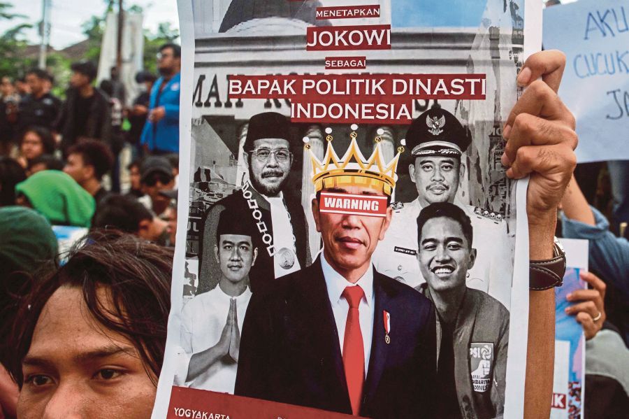  A protester holding a poster depicting Indonesian President Joko Widodo as the head of political dynasty at a rally in Yogyakarta on Monday. Criticism of dynastic politics has done little to erode Joko’s clout in the Indonesia election. AFP PIC 