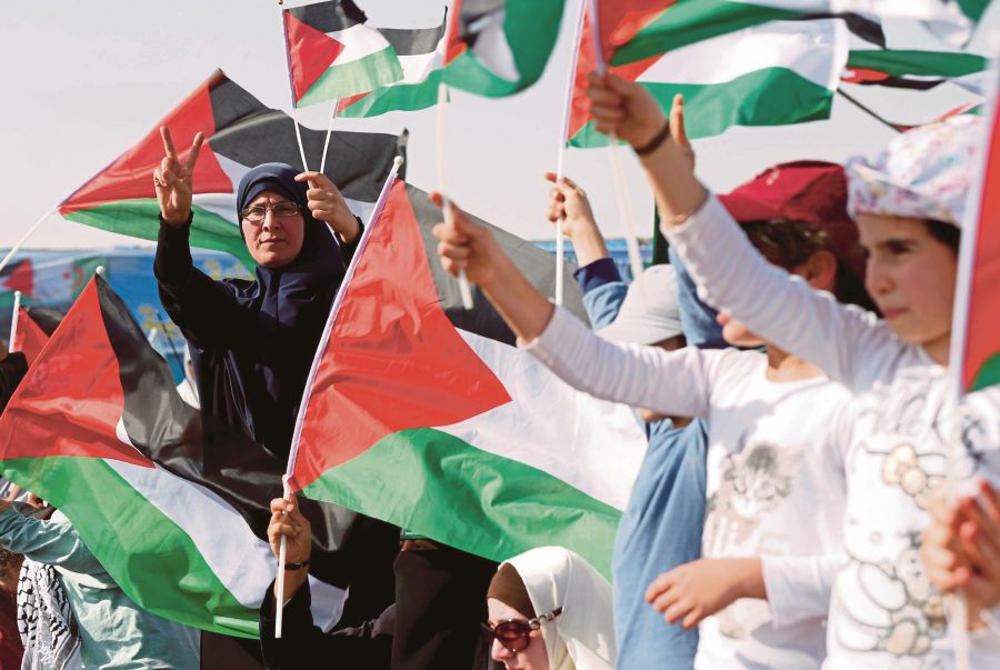 People waving Palestinian flags at a rally to mark the 70th anniversary of Nakba in Sweimeh, Jordan, on Friday. REUTERS PIC
