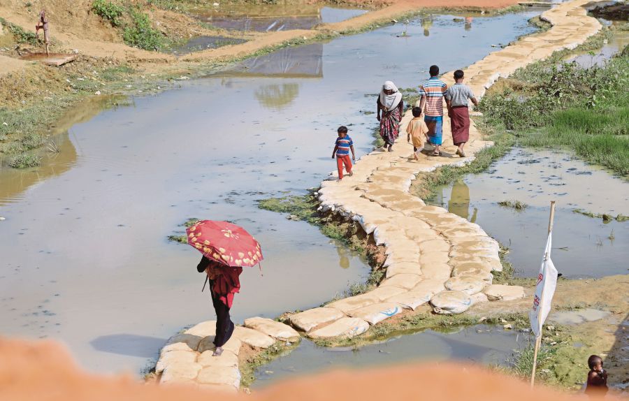 Rohingya refugees using a path made of sandbags to cross stagnant water at the Balukhali refugee camp near Cox’s Bazar in Bangladesh. More than 646,000 Rohingya have crossed the border from Myanmar into Bangladesh, following the Myanmar army’s August crackdown on Rohingya rebels in Rakhine State. (EPA PIC)