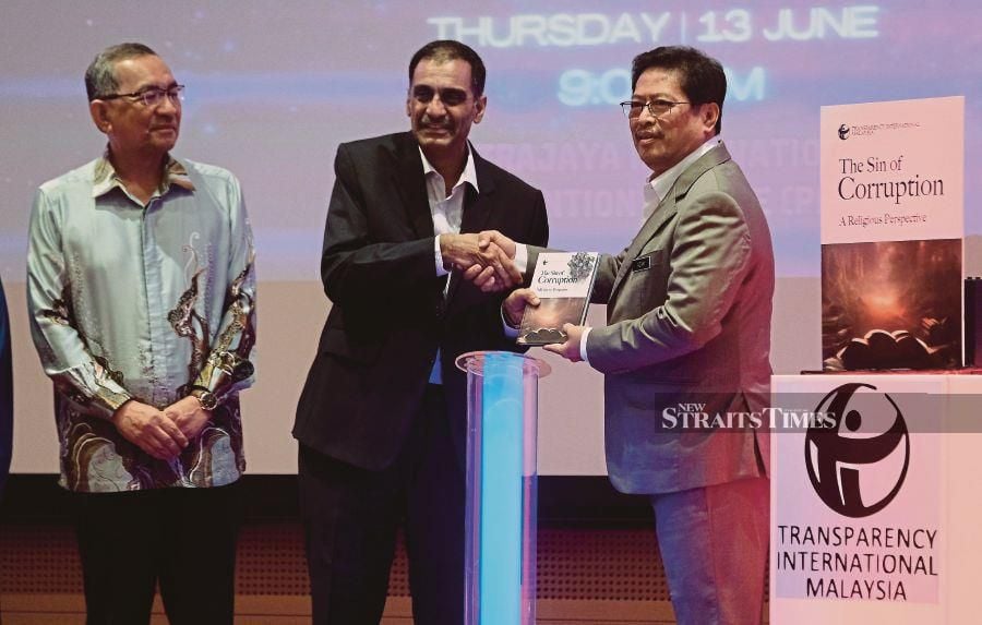 Transparency International Malaysia president Dr Muhammad Mohan (centre) with MACC chief commissioner Tan Sri Azam Baki (right) at the launch of The Sin of Corruption - A Religious Perpective book in Putrajaya. Also present was senior director of Jakim Dr Muhammad Yamin Ismail (left). - NSTP/MOHD FADLI HAMZAH