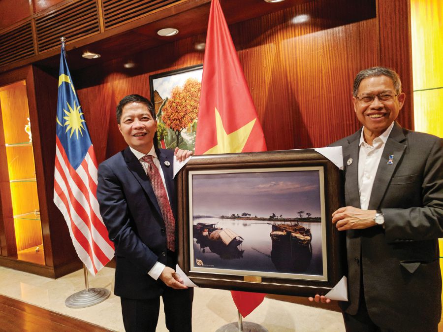 International Trade and Industry Minister Datuk Seri Mustapa Mohamed (right) receiving a painting from Vietnamese Minister of Industry and Trade Tran Tuan Anh on the sideline of the Asia-Pacific Economic Cooperation Summit in Danang, Vietnam, recently. 