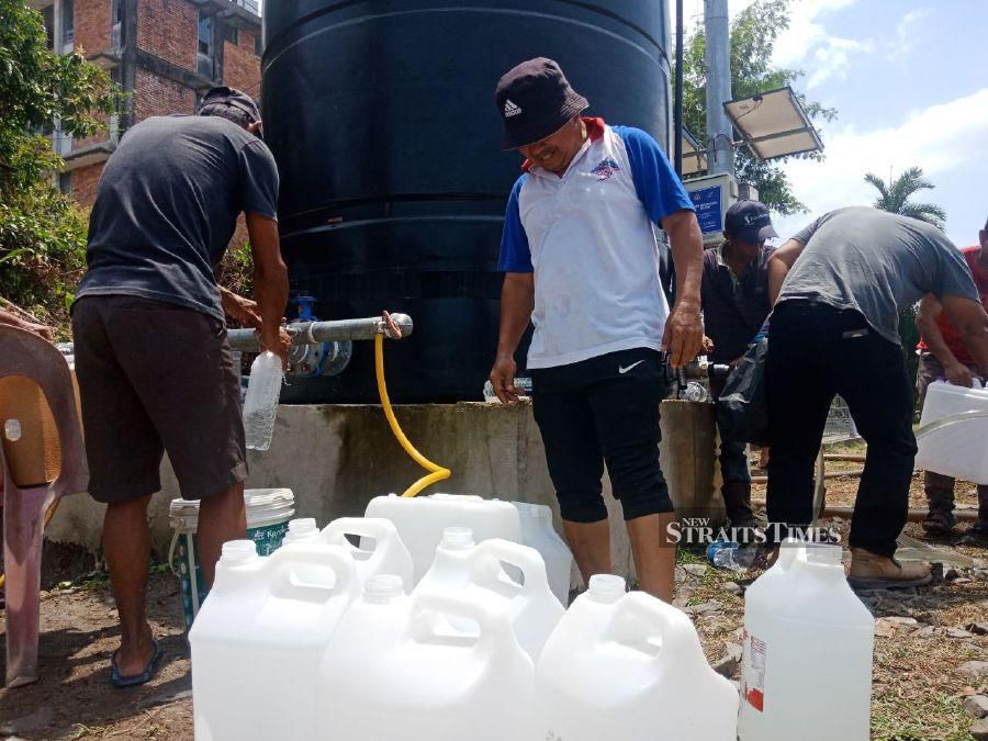 Residents collecting water supplied by lorries at Masjid Raudhatul Ilmiyyah in Kampung Kuala Papar. STR/RAFIQAH DAHALI