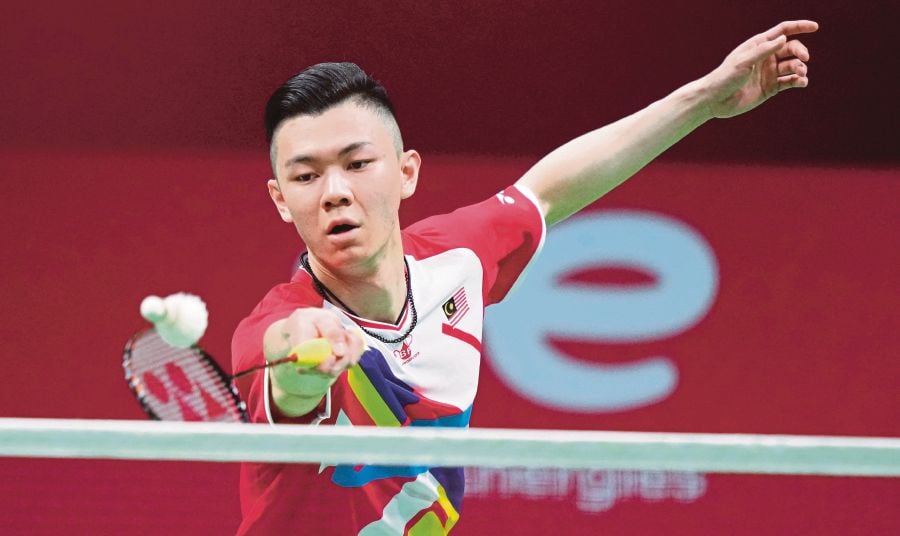 Malaysia’s Lee Zii Jia in action against Japan’s Kento Momota in the Group D match of the Thomas Cup in Aarhus, Denmark yesterday. -AFP PIC