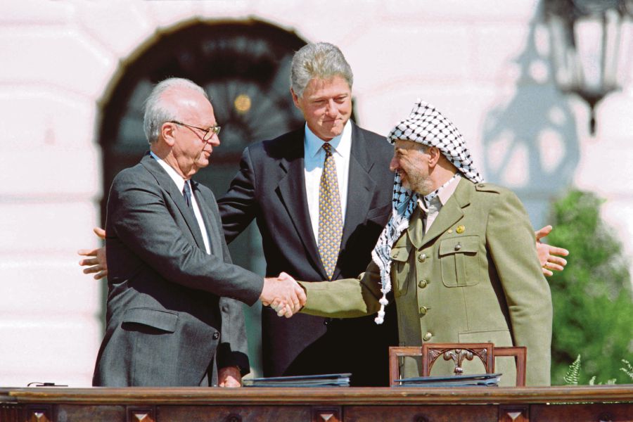 Then United States president Bill Clinton standing between Israeli Prime Minister Yitzhak Rabin (left) and PLO leader Yasser Arafat as they shake hands for the first time, at the White House in Washington DC on Sept 13, 1993, after signing the Israel-PLO Oslo Accords on Palestinian autonomy in the occupied territories. AFP PIC