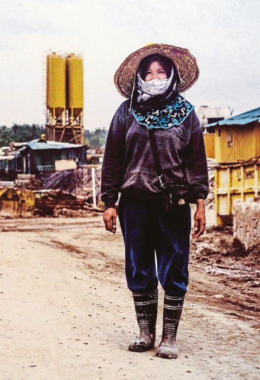 A portrait of a female migrant labourer in her work get-up. 
