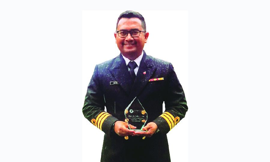 Commander Khairol Nizam Mansor holding a Kirsty Craig Associates Award trophy in Chester, England.