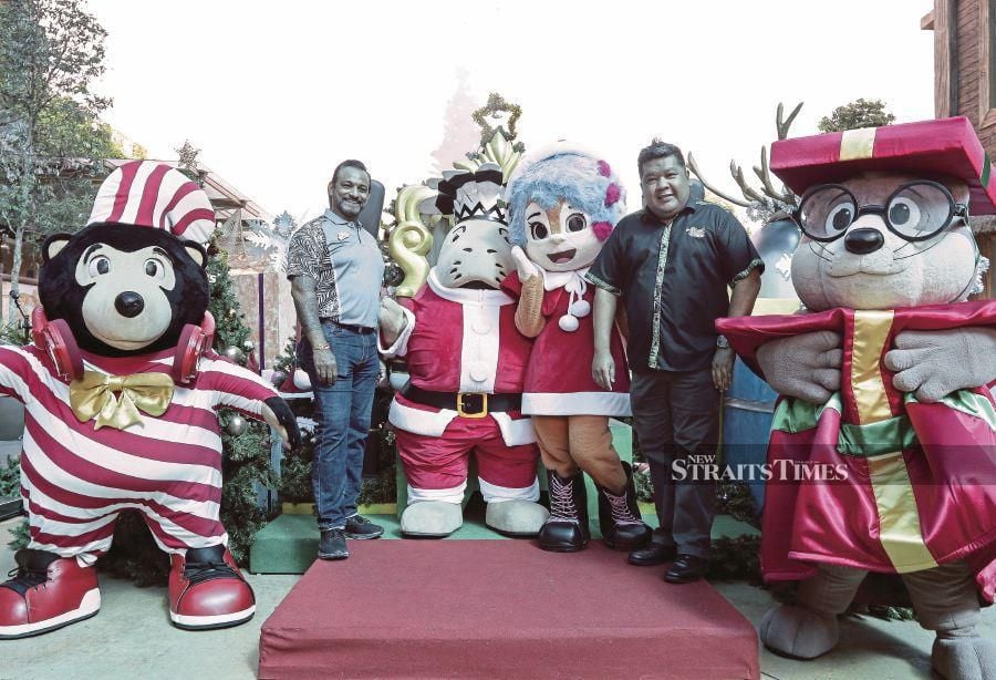 Gamuda Land General Manager (Leisure & Hospitality), Sanjay Nadarajah (second from right) poses with the ÕSplash SquadÕ mascot after officiating the SantaÕs Ho-Ho-Holidays campaign at SplashMania Waterpark. STR/SADIQ SANI