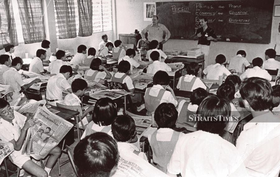 NIE coordinators John McFarland of ‘The Herald and Weekly Times’ and Peter Bunworth of ‘The Age’ from Melbourne, Australia, conducting a New Straits Times Newspaper-in-Education lesson at Chung Hua High School, Klang, on Jan 13, 1985. -NSTP/File pic