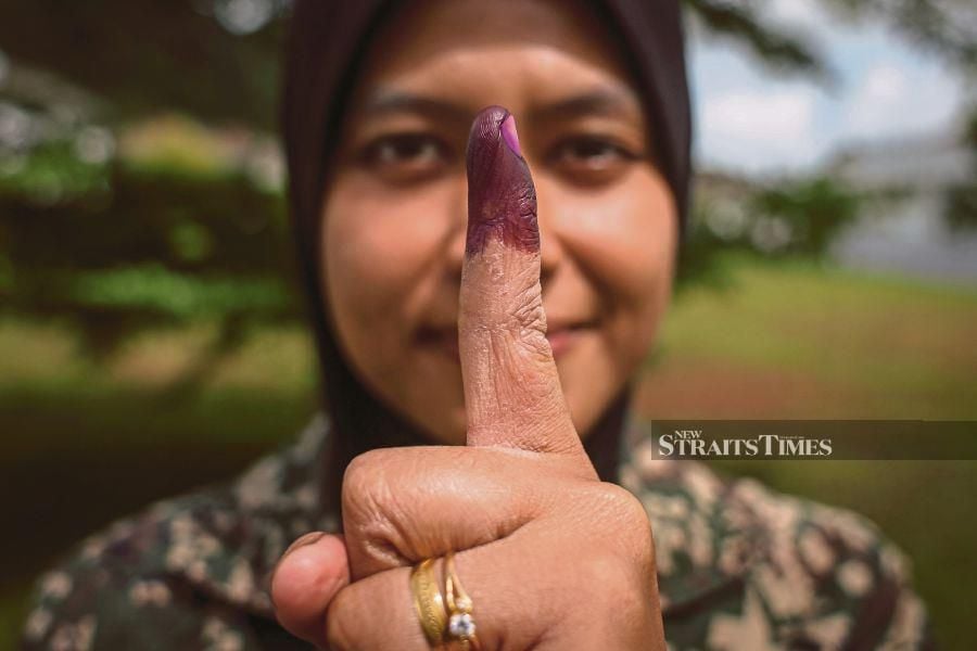  Lieutenant Nur Amirah Mohd Adnan showing her inked finger after casting her early ballot at Camp Bukit Cowder in Padang Besar, Perlis, yesterday. -NSTP/LUQMAN HAKIM ZUBIR