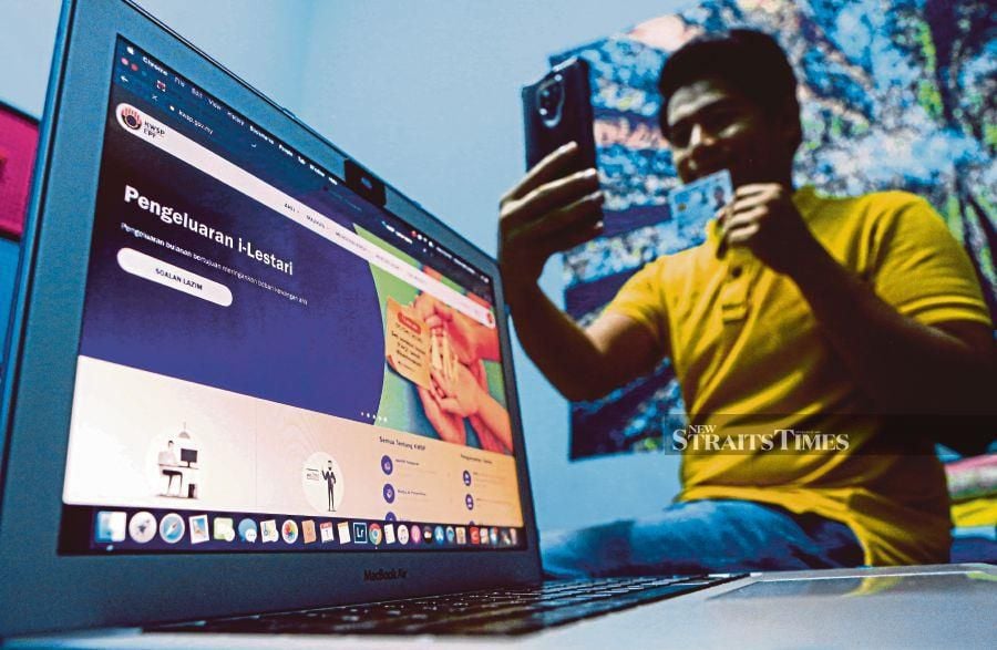 A man completing an online application to make a special withdrawal from his Employees Provident Fund account at the height of the Covid-19 pandemic in April 2020. The four special withdrawal schemes during the pandemic drained RM145 billion from EPF. FILE PIC 