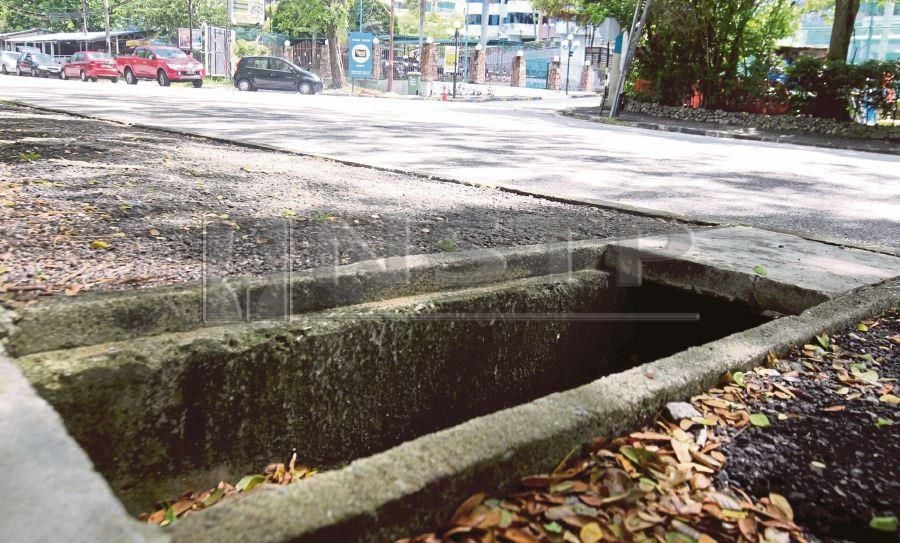 The uncovered drains pose a danger to pedestrians, more so when it rains. PIC BY DANIAL SAAD