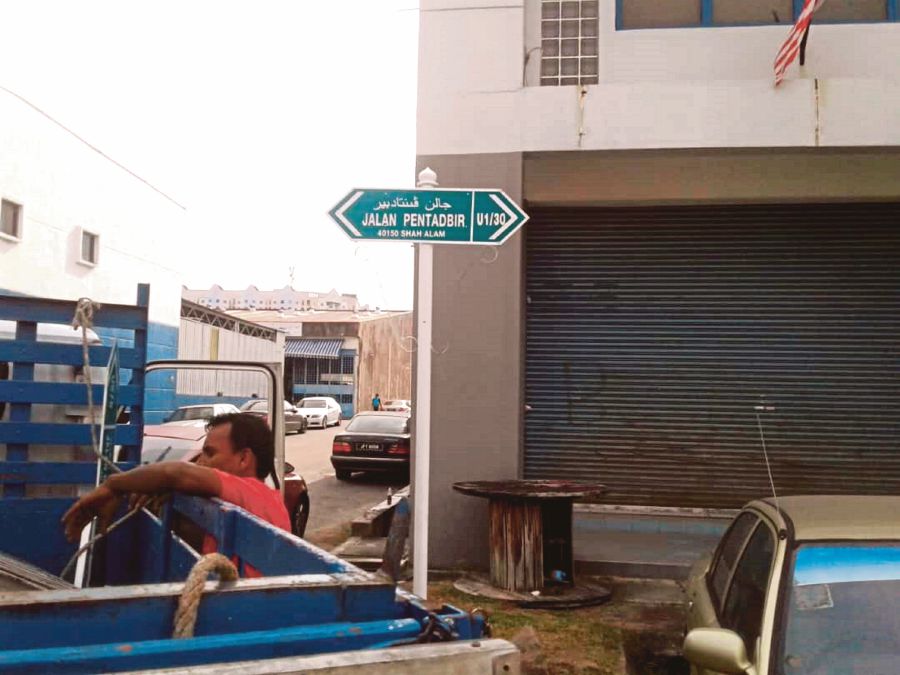 Shah Alam City Council workers replacing an old road sign. 