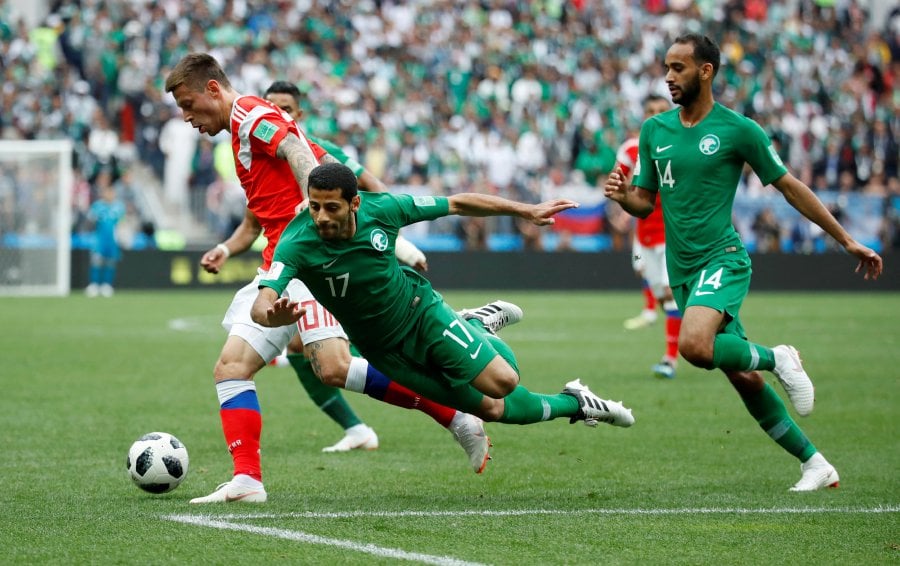  Saudi Arabia's Taisir Al-Jassim and teammate Abdullah Otayf in action with Russia's Fyodor Smolov in their World Cup match in Moscow on June 14, 2018. REUTERS pic
