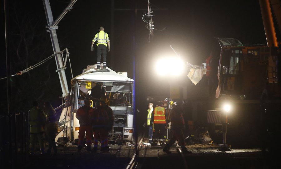 Firefighters and police work at the site of an accident in Millas, near Perpignan, southern France, on December 14, 2017, after a train crashed into a school bus at a level crossing. The bus, which was carrying around 20 students from a local secondary school, was struck by the train in Millas about 18 kilometres west (11 miles) of the city of Perpignan, close to the Spanish border. (AFP PHOTO) 