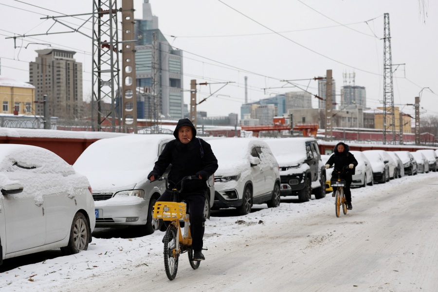 People ride bicycles on a road covered by snow following snowfall in Beijing, China December 15, 2023. REUTERS PIC