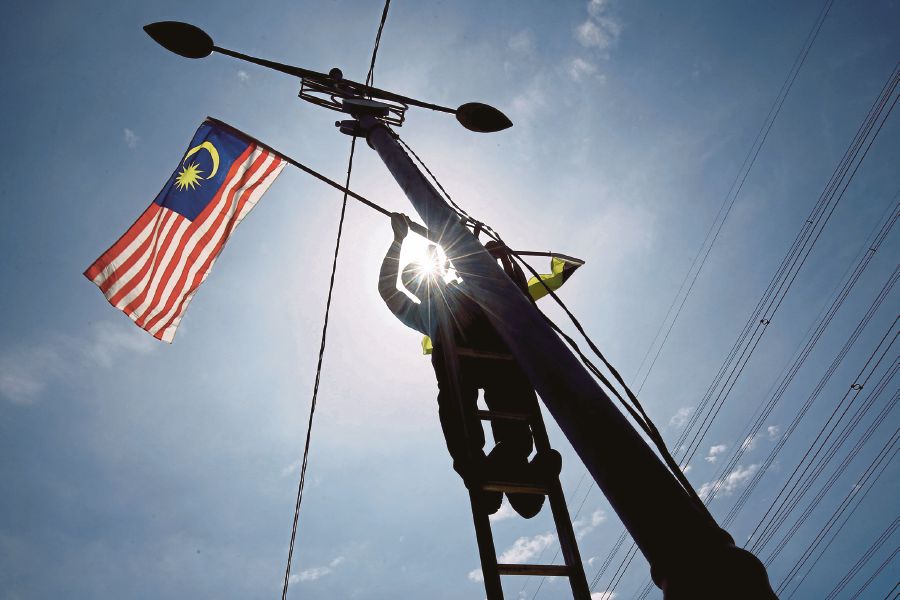 A Port Dickson Municipal Council employee putting up the Jalur Gemilang in Port Dickson, Negri Sembilan, recently. The West should stop carrying a broad brush and pronouncing how this or that place does not measure up. -BERNAMA pic