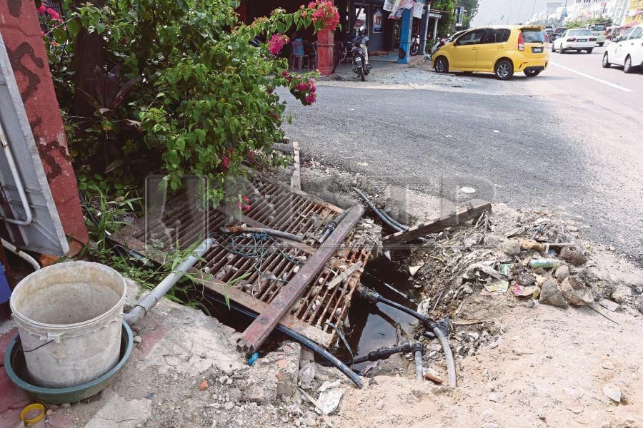  The hole at a road shoulder in Kampung Pasir Tumboh, opposite the Kentucky Fried Chicken outlet in Kota Baru, poses a danger to road users. PIC BY ZAMAN HURI ISA