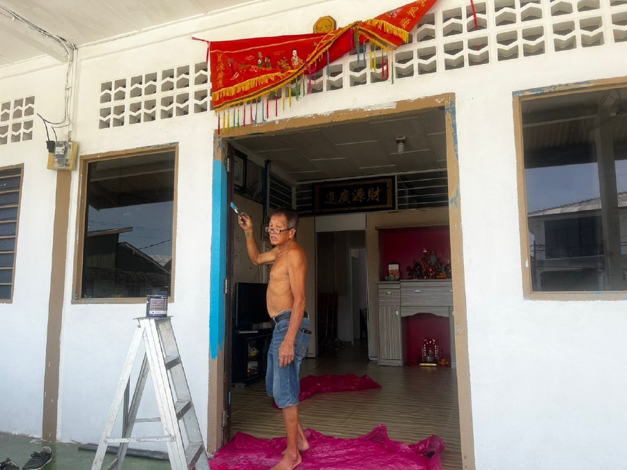 Liong Tiong Kiet painting his house