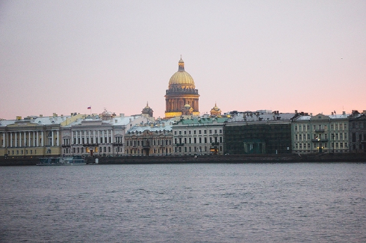 The banks of Neva River with rows of classic buildings and the gilded dome Saint Isaac Cathedral that make up St Petersburg.