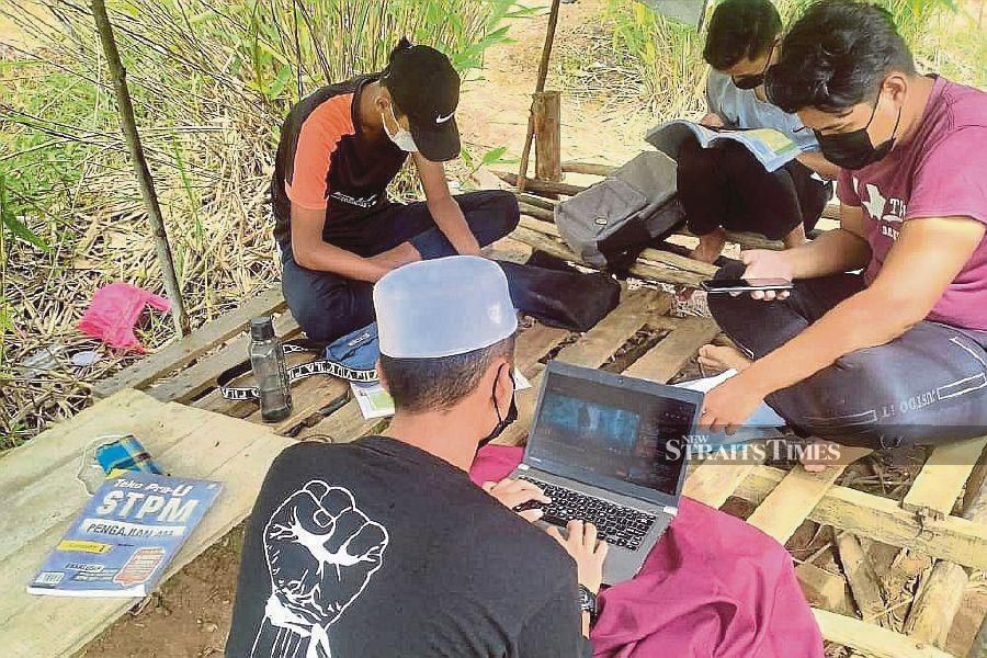  Students studying in a hilltop hut in Kampung Relai, Kerambit, in Lipis, Pahang, to get a broadband signal. -NSTP file pic 