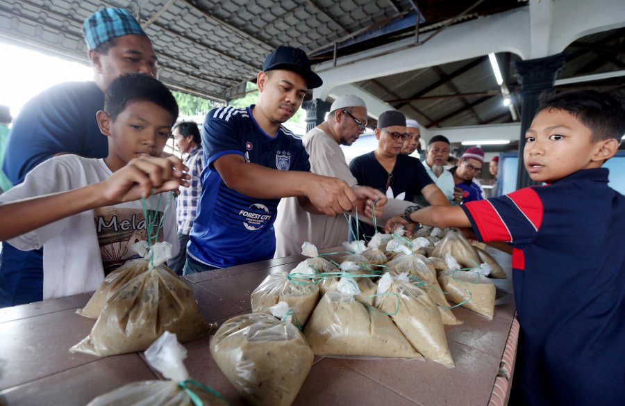 Some 2,000 'bubur lambuk' packets were quickly snapped by the public at the Kampung Melayu Majidee mosque. Pic by HAIRUL ANUAR RAHIM