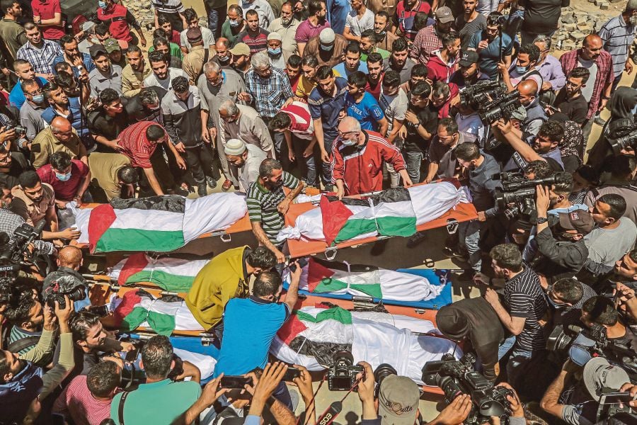 Palestinians attending the funeral of 10 members of the Abu Hatab family in Gaza City on  May 15. They were killed in  an Israeli airstrike on the Al-Shati refugee camp in the Gaza Strip. - EPA PIC   