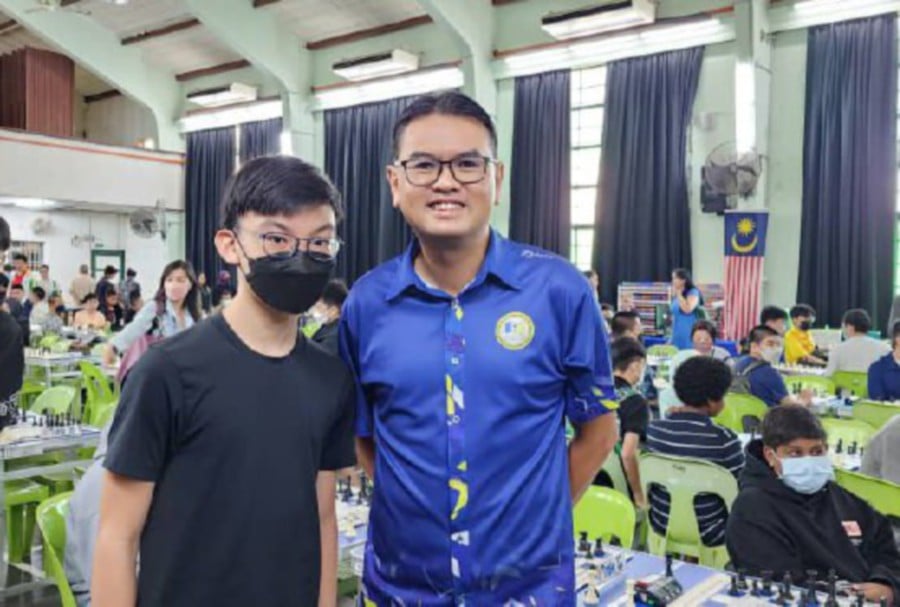 Penang State Sports Council director Harry Chai (right) with a chess player during a recent junior competition. Pic from Penang Chess Association
