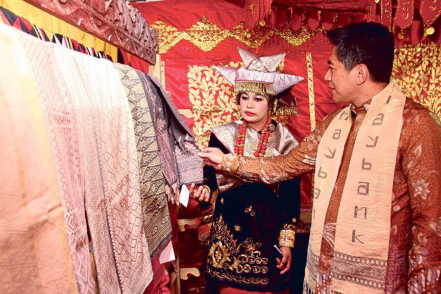 Maybank Indonesia president/director Taswin Zakaria checks out the eco-woven fabric from West Sumatra.