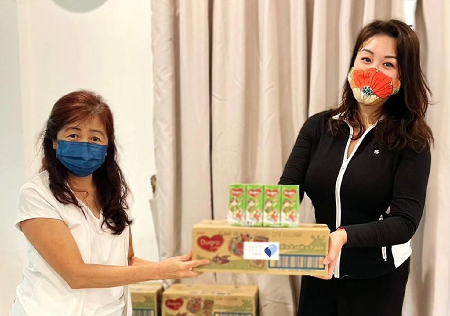 President of the Society of Hope, Josephine Hadikusumo (wearing black, right) said free milk distribution is an ongoing exercise to bring relief to families impacted by the Covid-19 pandemic. -Pic courtesy of Josephine Hadikusumo.