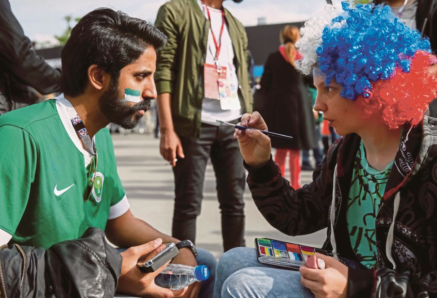 A Saudi Arabia fan has his face painted before the match on Thursday. REUTERS PIC