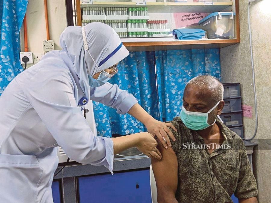 Samuel Surej, 53, voluntarily gets himself vaccinated at a clinic in Jalan Perak, George Town, yesterday. PIC BY ZUHAINY ZULKIFFLI