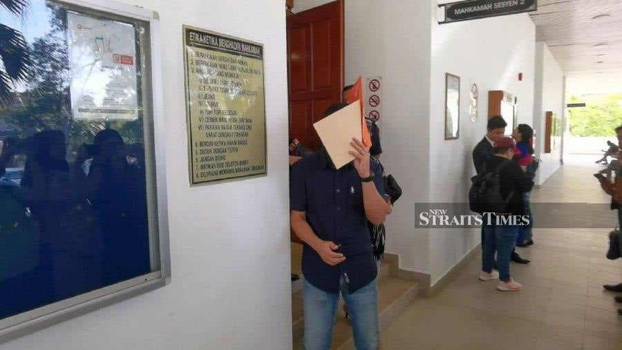 Mohd Fazli Azizan covers his face from photographers as he leaves the Alor Star Sessions court after the trial. - NSTP/ZULIATY ZULKIFFLi