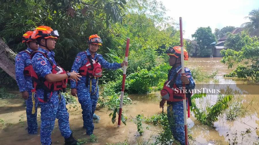 Kedah Malaysian Civil Defence Force (APM) disaster management secretariat division chief Mohd Suhaimi Mohd Zain (2nd-left) with his officers making rounds to monitor the flood situations in Alor Star. - NSTP/ZULIATY ZULKIFFLI