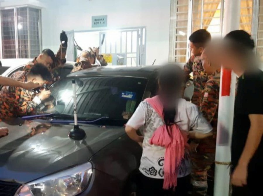 A one-year-old boy was rescued by firefighters after being locked in a car for about 20 minutes in the parking lot of an apartment on Jalan Bundusan here this afternoon. PIC COURTESY OF FIRE & RESCUE DEPT
